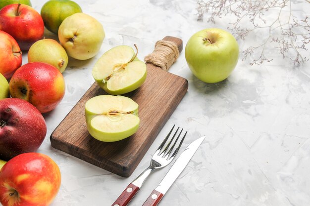 Vista frontale mele verdi con altri frutti sul tavolo bianco mela frutta matura pera fresca