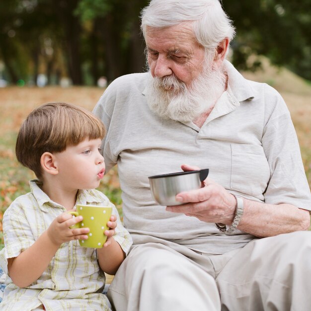 Vista frontale nonno e nipote di bere il tè