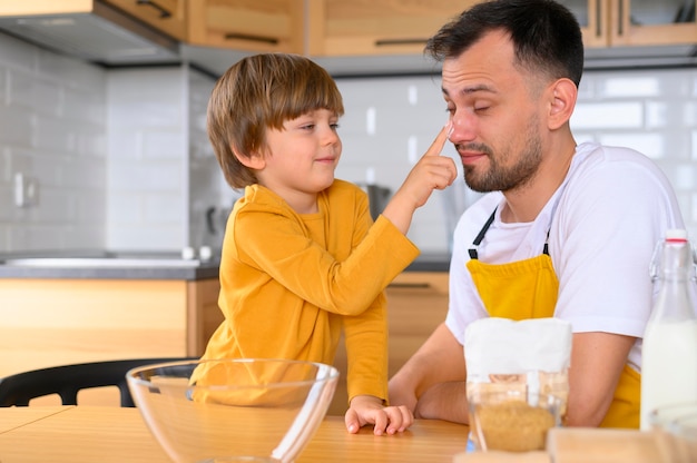 Vista frontale padre e figlio in cucina