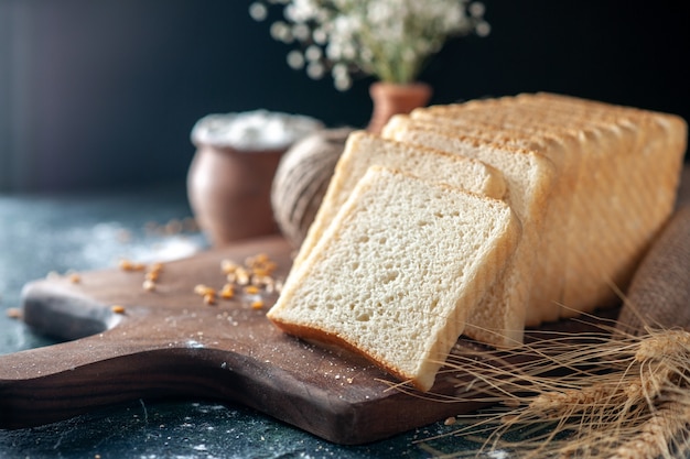 Vista frontale pane bianco affettato su scrivania scura pasta per panini panetteria tè mattina pasticceria cibo pagnotta per la colazione