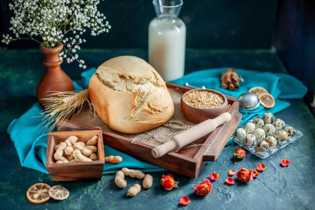 Vista frontale pane fresco con uova e latte su torta blu scuro torta tè panino zucchero biscotto colazione pasta cuocere