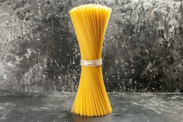 Vista frontale pasta italiana lunga cruda sul pasto fotografico di cucina di colore alimentare grigio chiaro