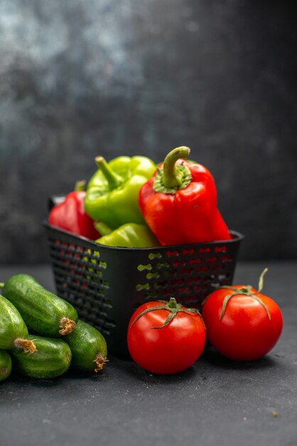 Vista frontale peperoni freschi con verdure su sfondo scuro dieta alimentare salute insalata pasto