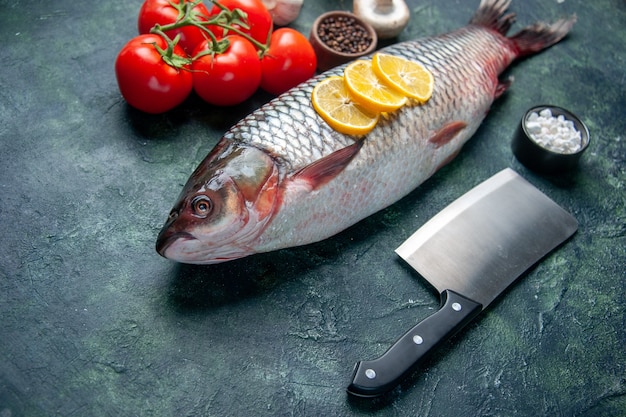 vista frontale pesce crudo fresco con fette di limone e pomodori sulla superficie blu scuro farina di pesce squalo oceano orizzontale cibo carne animale acqua cena