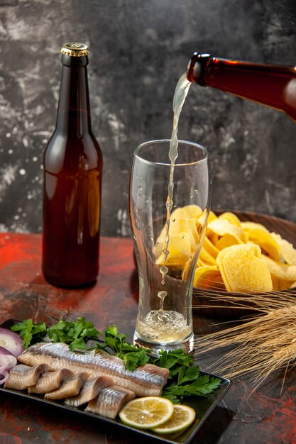 Vista frontale pesce fresco affettato con verdure e birra sulla foto scura spuntino carne farina di frutti di mare colore