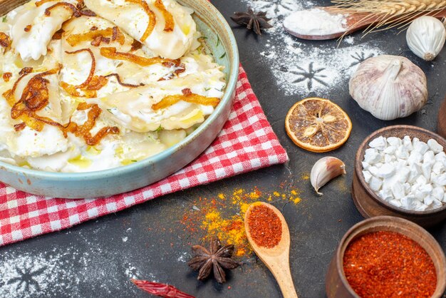 Vista frontale pezzi di pasta cotti con cipolle fritte e ingredienti diversi su sfondo scuro pasto pepe cena cibo olio piatto da cucina