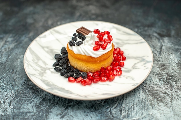 Vista frontale piccola deliziosa torta con cioccolato e uvetta su sfondo chiaro-scuro