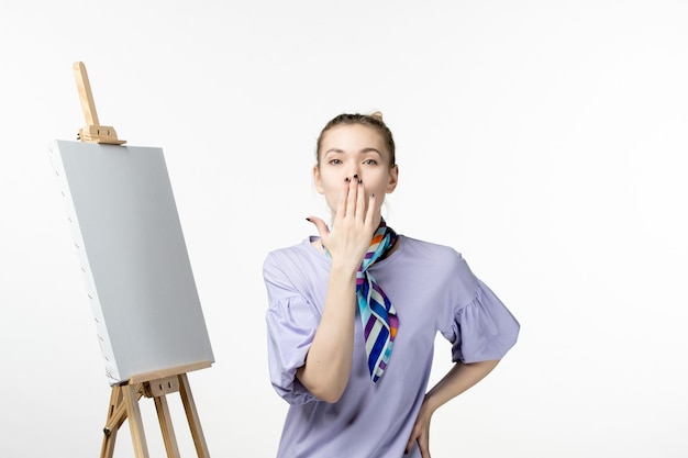 Vista frontale pittrice con cavalletto per dipingere su parete bianca mostra di artisti fotografici pittura disegno arte emozioni