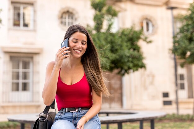 Vista frontale piuttosto giovane donna che parla al telefono