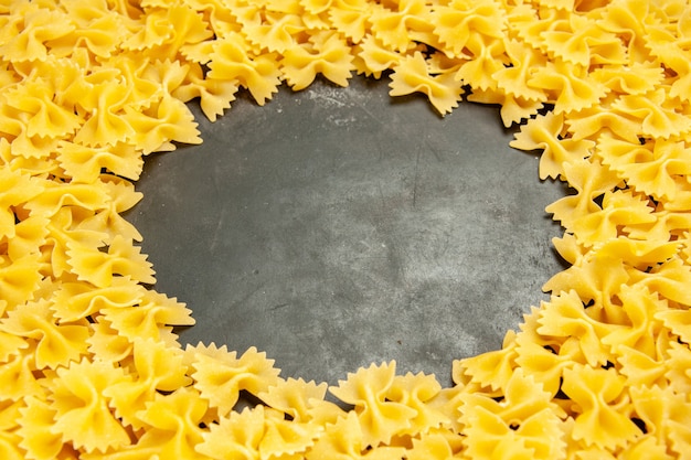 Vista frontale poca pasta cruda su foto scura molti pasta alimentare pasta italiana colore