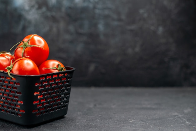 Vista frontale pomodori rossi freschi all'interno del cesto su sfondo scuro insalata colore maturo pasto foto spazio libero