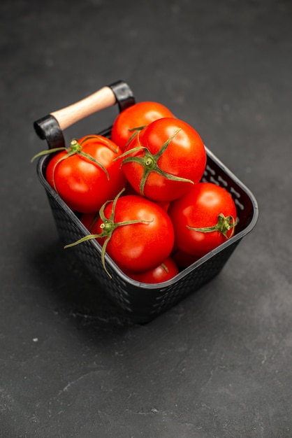 Vista frontale pomodori rossi freschi all'interno del cesto su sfondo scuro insalata di verdure mature foto