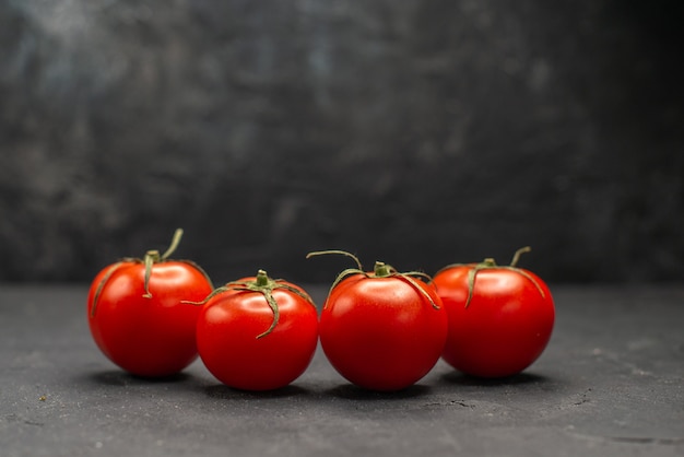 Vista frontale pomodori rossi freschi su sfondo scuro insalata di foto a colori pasto maturo