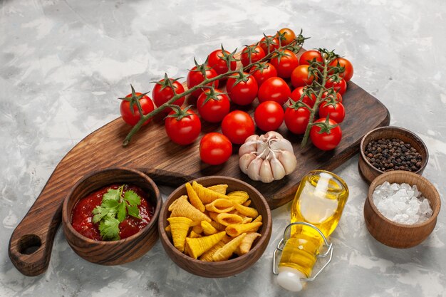 Vista frontale pomodorini freschi con condimenti su insalata di salute alimentare farina di verdure superficie bianca