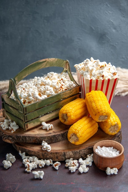 Vista frontale popcorn fresco con calli gialli sulla superficie scura snack popcorn cibo mais