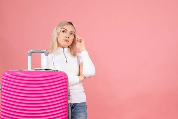 Vista frontale premurosa bella donna con la valigia rosa