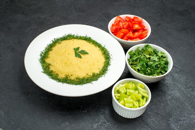 Vista frontale purè di patate con verdure e pomodori freschi a fette su spazio grigio