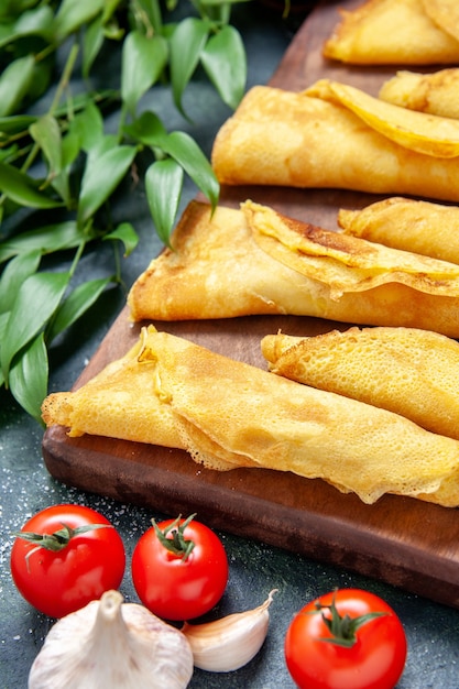 Vista frontale ravvicinata deliziose frittelle arrotolate su torta di farina di colore scuro torta di carne torta calda torta di pasta dolce