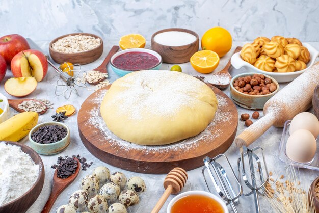 Vista frontale ravvicinata della pasticceria cruda e set di vari alimenti grattugia su sfondo di ghiaccio