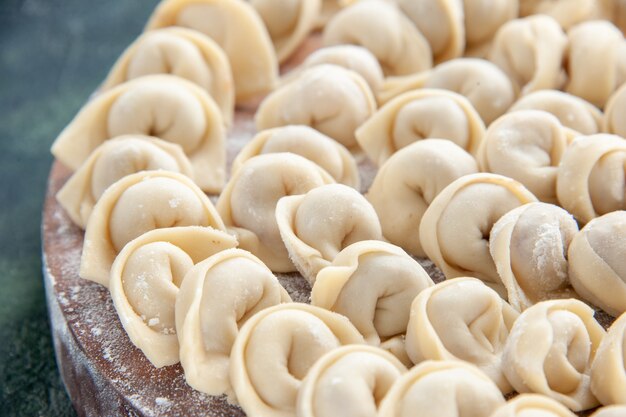 Vista frontale ravvicinata gustosi gnocchi su pasta blu scuro colore carne cibo pasto calorico piatto alimentare