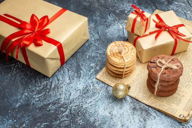 Vista frontale regali di Natale con biscotti e giocattoli su un regalo di Natale con foto a colori di capodanno chiaro-scuro