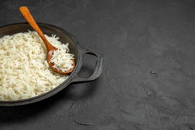 Vista frontale riso cotto all'interno della padella su superficie grigio scuro cibo cibo riso cena orientale