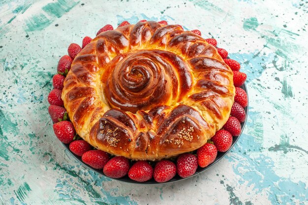 Vista frontale rotonda deliziosa torta con fragole rosse fresche sulla superficie azzurra torta pasticceria pasta zucchero biscotto dolce