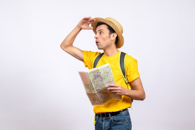 Vista frontale si chiedeva il giovane con cappello di paglia e t-shirt gialla tenendo la mappa guardando qualcosa
