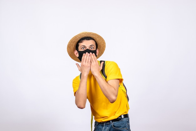 Vista frontale sorpreso giovane uomo con maschera e maglietta gialla