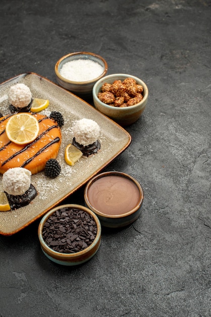 Vista frontale squisita piccola torta con caramelle al cocco su sfondo grigio scuro torta tè biscotto biscotto dolce caramella