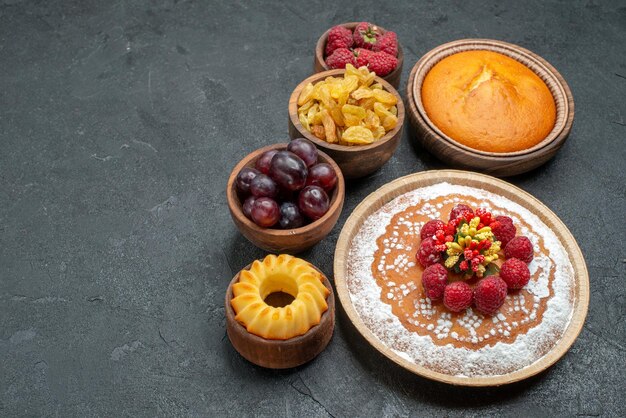 Vista frontale squisita torta di lamponi con uvetta e frutta su sfondo grigio torta tè biscotto torta biscotto dolce