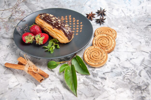 Vista frontale squisiti bignè al cioccolato con biscotti su tavola leggera torta biscotto dessert