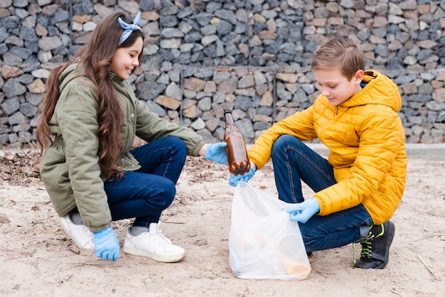 Vista frontale su bambini con sacchetti di plastica