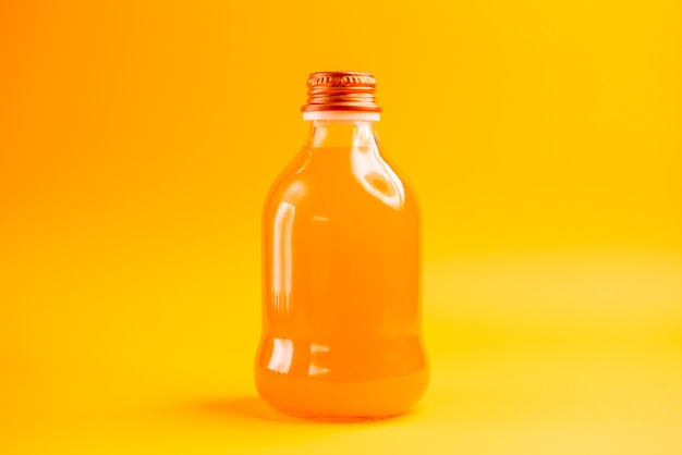 Vista frontale succo d'arancia all'interno della bottiglia su sfondo arancione colore succo limonata frutta
