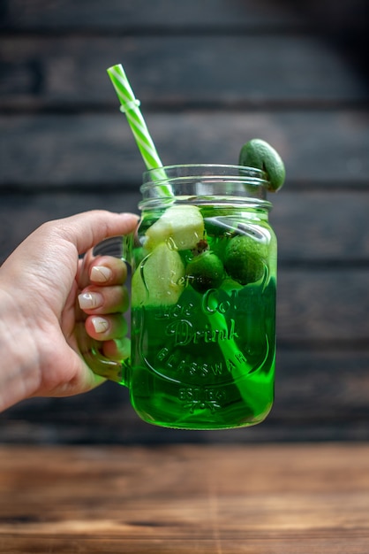 Vista frontale succo di feijoa fresco all'interno lattina con paglia su bar scuro cocktail di frutta foto colore bevanda bacca