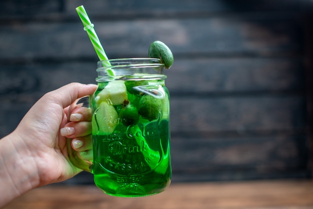 Vista frontale succo di feijoa fresco all'interno lattina con paglia su bar scuro cocktail di frutta foto colore bevanda bacca