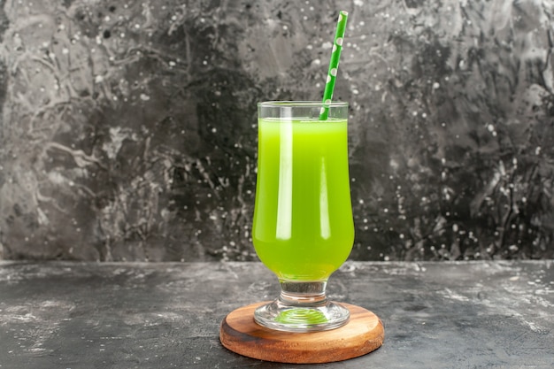 Vista frontale succo di mela verde all'interno del bicchiere con paglia su foto a colori grigio chiaro drink cocktail bar fruit