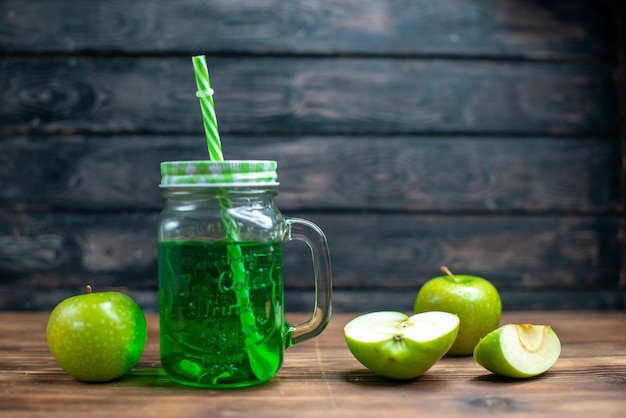 Vista frontale succo di mela verde all'interno lattina con mele verdi fresche sulla scrivania in legno bevanda foto cocktail bar colore frutta