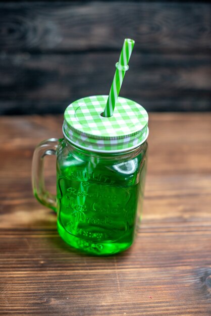 Vista frontale succo di mela verde all'interno può sulla scrivania in legno marrone bere foto cocktail colore frutta