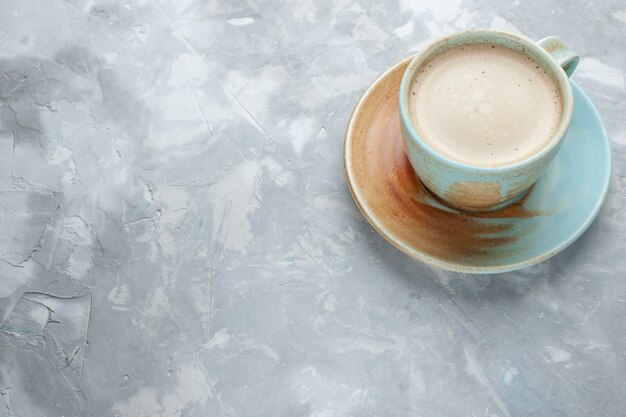 Vista frontale tazza di caffè con latte all'interno della tazza sullo scrittorio bianco bere caffè latte scrivania