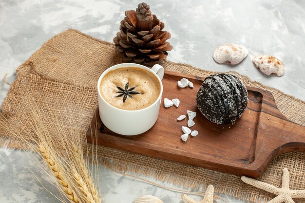 Vista frontale tazza di caffè espresso con torta al cioccolato sulla superficie bianca