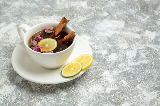 Vista frontale tazza di tè al limone sulla superficie bianca tè bevanda calda dolce zucchero colazione