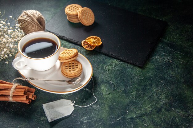 vista frontale tazza di tè con biscotti dolci su superficie scura pane bevanda cerimonia colazione dolce foto mattina zucchero torta colori di vetro