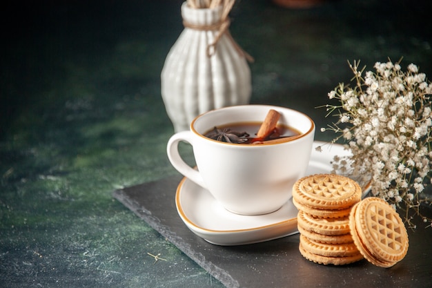 vista frontale tazza di tè con biscotti dolci sulla superficie scura pane bevanda cerimonia vetro dolce colazione torta colore zucchero mattina