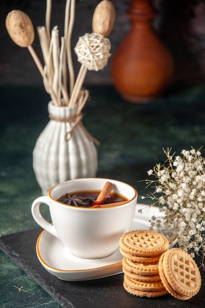 vista frontale tazza di tè con biscotti dolci sulla superficie scura pane bevanda cerimonia vetro torta dolce foto a colori zucchero mattina