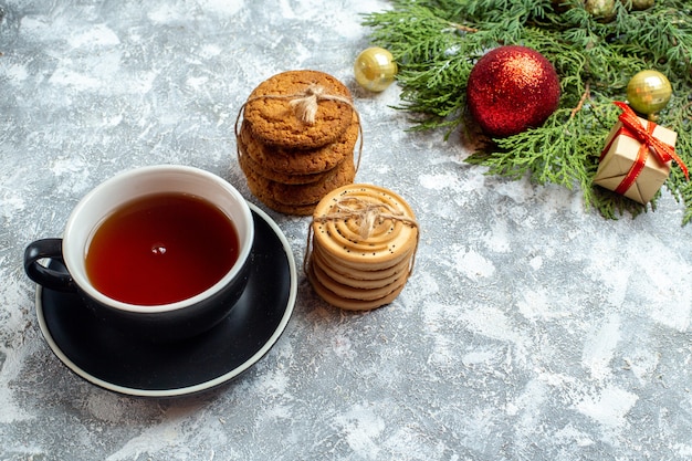 Vista frontale tazza di tè con biscotti e giocattoli su sfondo bianco