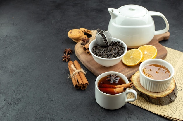 Vista frontale tazza di tè con limone e miele su sfondo scuro colazione a base di uova pasto tavolo a colori caffè mattutino cibo