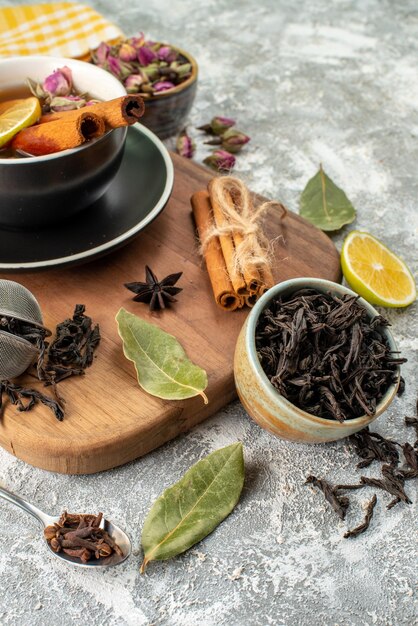 Vista frontale tazza di tè con limone sullo sfondo chiaro cerimonia dei fiori sapore mattutino frutta colazione colore alimentare