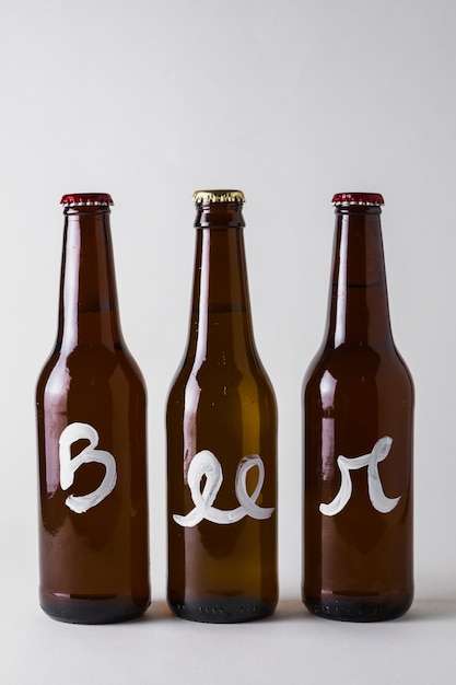 Vista frontale tre bottiglie di birra allineate sul tavolo