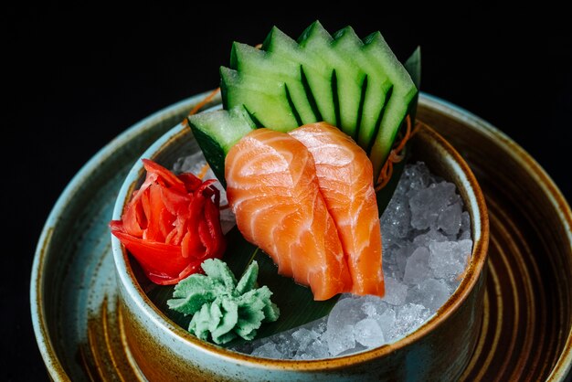 Vista frontale tritato pesce rosso affumicato con wasabi tritato cetriolo e zenzero nel ghiaccio